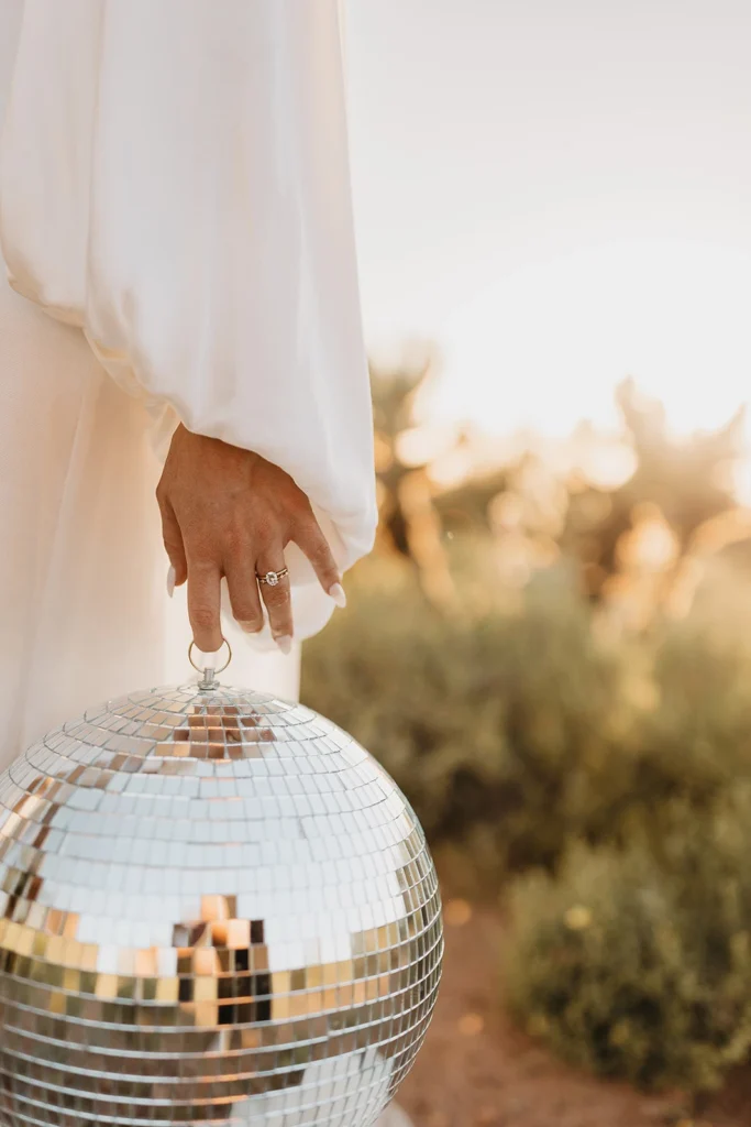 Person holding a disco ball, outdoors