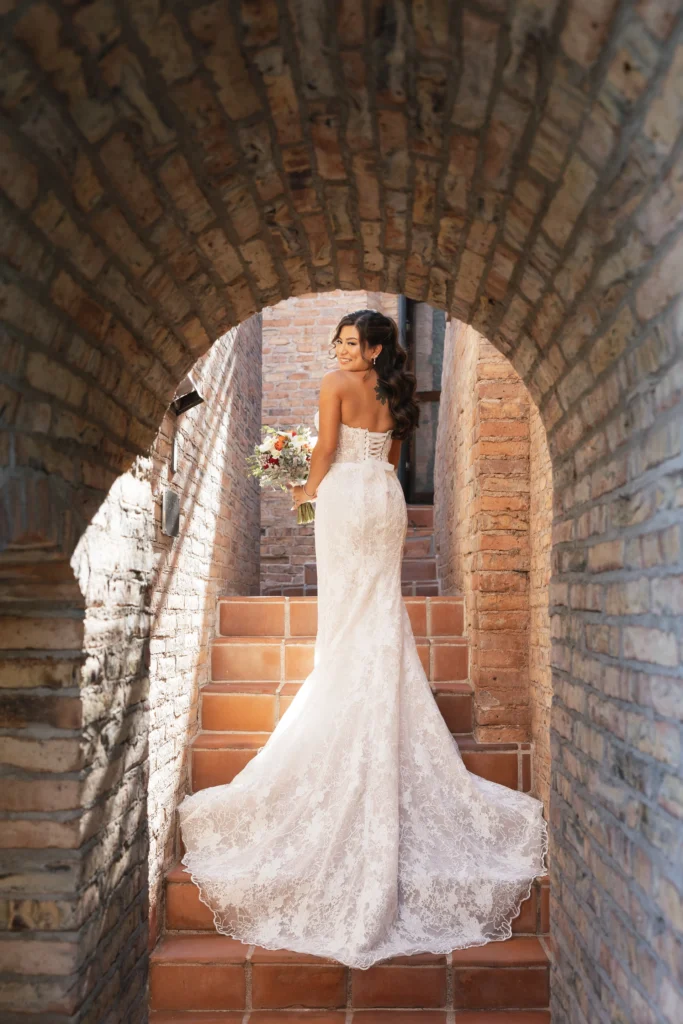The bride in a small corridor with a brick wall and arch at the Eagle Dancer Resort 